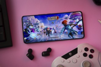 Dhaka, Bangladesh- 15 July 2025: A close-up of a gamepad with the Clash of clans seen on smartphone