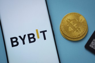Dhaka, Bangladesh- 15 July 2025: Bybit logo on smartphone screen near Bitcoin coin and QR code on