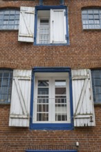 Window with shutters, brick façade, warehouse building, old town centre, Husum, North Frisia,