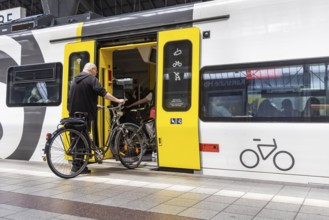 Platform with travellers and bicycles in front of the bicycle compartment. Central station with