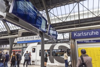 Platform with travellers at Karlsruhe main station with S-Bahn. Karlsruhe, Baden-Württemberg,