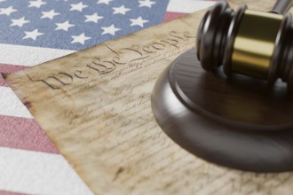 United states constitution, gavel and american flag resting on table