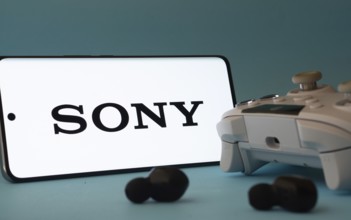 Dhaka, Bangladesh- 02 July 2025: A smartphone with a sony icon next to a controller and earbuds on