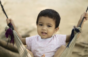 Gazipur, Bangladesh- 22 June 2025: A close up of a child playing on a swing