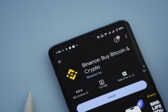 Dhaka, Bangladesh- 29 May 2025: On a blue surface, a smartphone displays the binance app within the