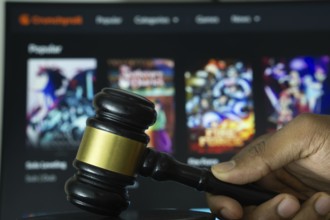 Dhaka, Bangladesh- 20 June 2025: A hand holds a gavel in front of a computer screen displaying