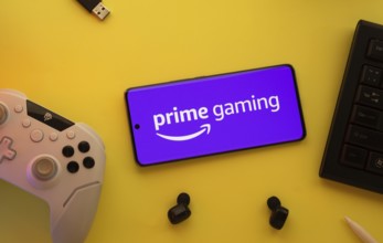 Dhaka, Bangladesh- 22 June 2025: Smartphone with prime gaming logo, game controller, and earbuds on