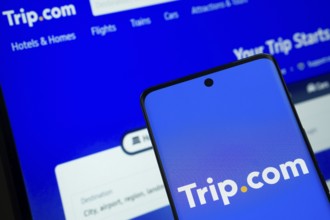 The logo of the trip.com is displayed on a smartphone screen, and the website trip.com is visible