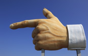 Plastic sculpture of a human hand with an outstretched index finger to indicate a direction