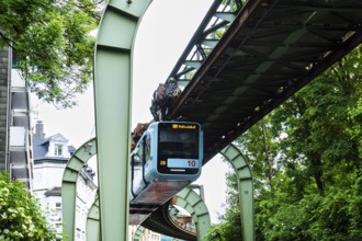 The Wuppertal suspension railway runs through Vohwinkel in front of buildings from the Wilhelminian