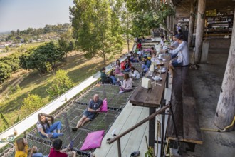 Customers eat, drink and relax on a net suspended over the hillside at the Akha Cottage restaurant