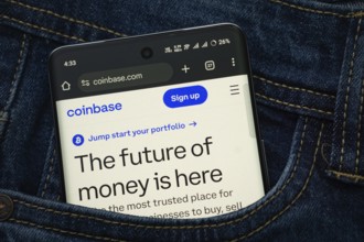 Dhaka, Bangladesh- 15 June 2025: A smartphone displaying the coinbase.com web interface peeks out