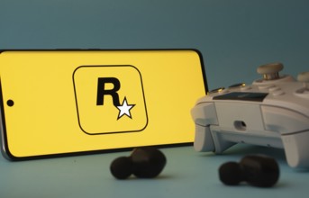 Dhaka, Bangladesh- 17 June 2025: A smartphone with a rockstar games app icon next to a controller