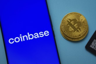 Dhaka, Bangladesh- 16 June 2025: Coinbase logo on smartphone screen near Bitcoin coin and QR code