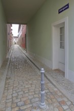 Narrow alley with houses, passage, subway, long narrow, alleyway with cobblestones and vanishing