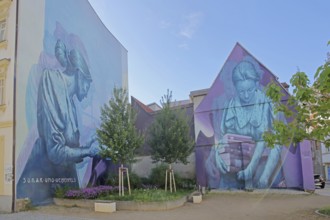 Two Mural Knowledge by Sokar Uno 2023, blue violet house wall, woman with stack of books, books,