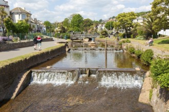 Dawlish Water river flowing through park gardens in town centre, Dawlish, south Devon, England, UK