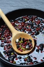 Dried beans placed in water to soak, wooden spoon