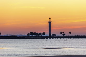 Sunrise silhouette of Broadwater Beach Marina Light at Biloxi, Mississippi, USA