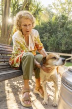 Senior woman enjoying a peaceful moment outdoors, sitting on a wooden bench in her backyard and