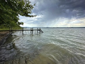 Dark clouds, thunderstorm atmosphere, shore area with jetty at Lake Starnberg, Bavaria, Germany