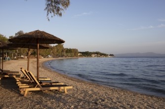 Sun loungers on the beach of Kala Nera at sunset on the Pagasitic Gulf, Pelion or Pelion Peninsula,