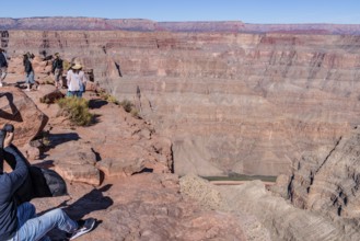 Tourists on the edge of the canyon at Guano Point area of Grand Canyon West near Peach Springs,