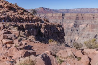 Visitors walk along the canyon rim to the location of the old mining cable structure at Guano Point
