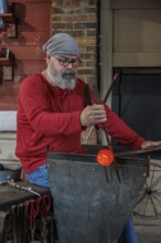 Glass blower demonstrates the art of blowing glass at the Dollywood amusement park in Pigeon Forge,
