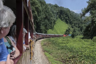 Great Smoky Mountains Railroad passengers looking out the windows of the open air train car while