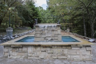 Water fountain with fairies and a sign reading Don't piss off the fairies near the entrance to
