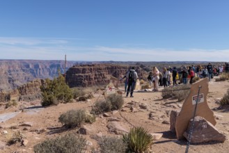 Visitors try to take photos of the canyon from a chained area nera the rim at the Eagle Point area