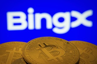 Close-up of Bitcoin coins with the BingX logo visible on a screen in the background