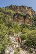 Woman hiking in the corlorful gorge La Garganta Verde, Sierra de Grazalema, Andalusia, Spain