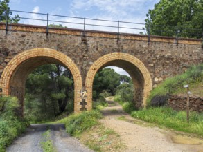 Cycle path via verde de Riotinto, on old railroad bridge, signpost to village Minas de Rio Tinto,