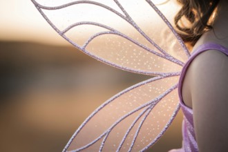 Close up of beautiful purple fairy wings on child. Magical costume detail concept. Generative AI,