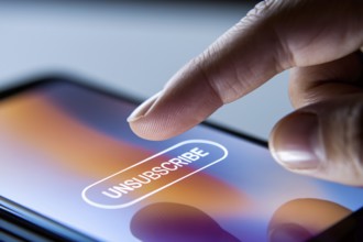 Close up of person's finger hovering over unsubscribe button on mobile phone screen. Generative Ai,
