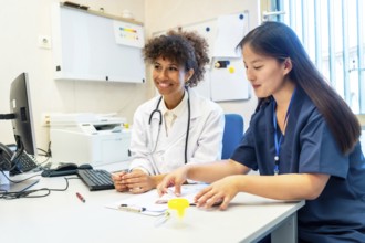 Two female doctors are reviewing a medical chart together, demonstrating teamwork and expertise in