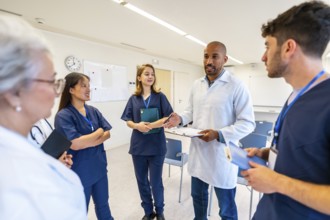 Doctors and nurses participating in a medical briefing, exchanging ideas and information for better