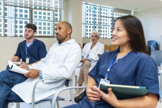 Doctors and nurses listening to presentation during medical conference in hospital meeting room