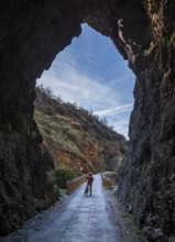 Cyclist on the Tranvía de Sierra Nevada, former railroad track, leading to the trail Vereda de la