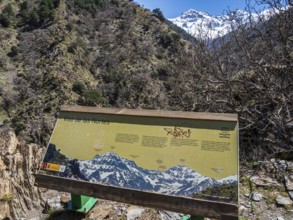 Information board, hiking trail Vereda de la Estrella, snow-covered mountain range in early spring,