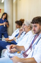 Exhausted doctors and nurses yawning and sitting in a hospital corridor, waiting for patients after