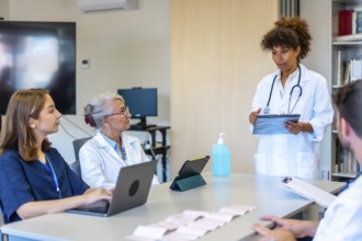 Doctors and nurses participating in a medical briefing, analyzing patient data and treatment plans