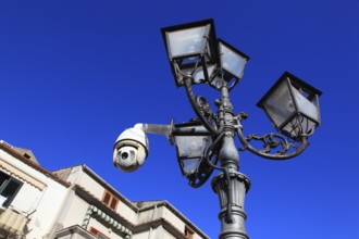 Surveillance camera on a lamppost in a public space
