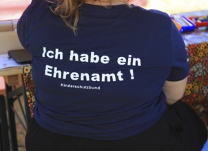 Overweight woman wearing a blue T-shirt with the inscription Ich habe ein Ehrenamt,