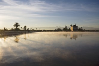 The Menara gardens, basin and minzah, a palace-like pavilion, High Atlas mountains behind, Morocco
