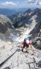 Mountaineer with helmet climbing in a secured via ferrata, Zugspitz via ferrata, ascent to the
