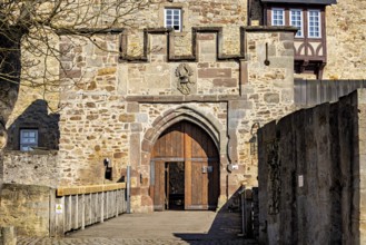 Medieval castle gate with stone walls and a heraldic coat of arms above it, The gate of Spangenberg