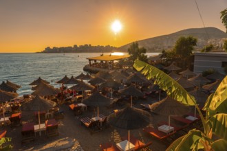Beautiful resort with umbrellas by the sea at sunset in Sarande or Saranda on the Albanian riviera,